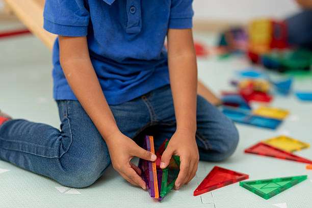 child playing with colorful magnetic tiles