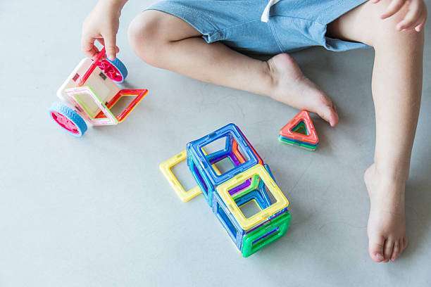 Toddler playing with magnetic building tiles