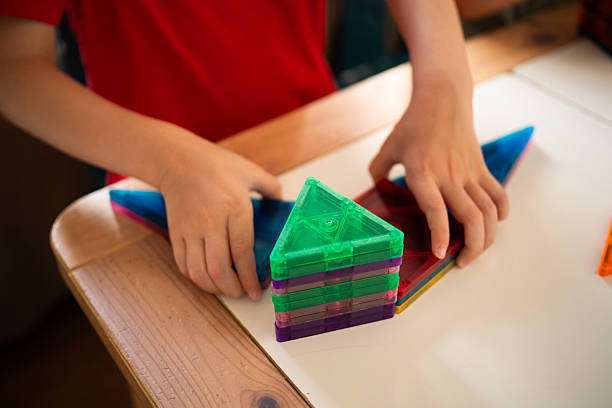 Toddler playing with magnetic tiles