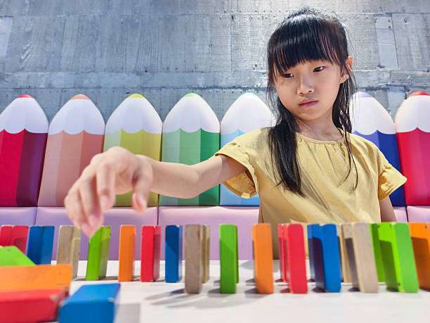 toddler girl playing colorful magnetic tiles