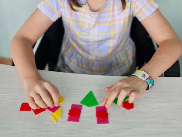 toddler girl playing colorful magnetic tiles