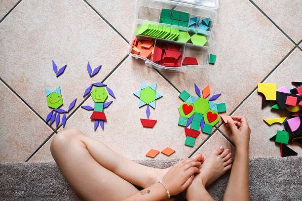 Caucasian baby girl wearing a pajamas, builds with magnetic tiles