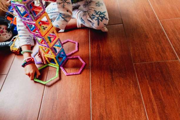 Child playing with building blocks to learn motor and social skills. magnetic tiles