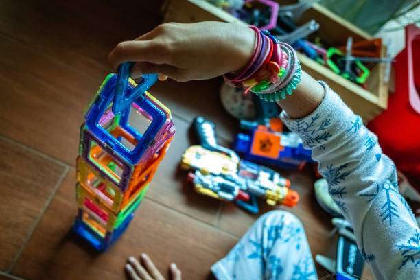 View of toddler playing with magnet letters text on magnetic tiles