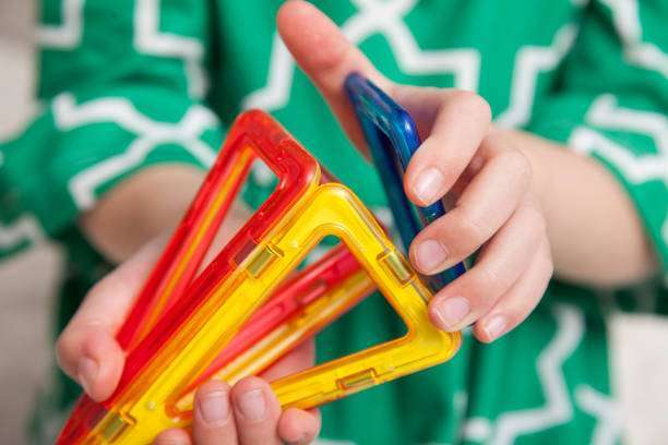 Little girl playing at home with interactive magnet toys. Leisure games: games.magnetic tiles